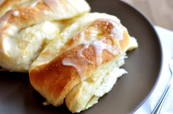 Top view of lightly golden orange sweet rolls with a drizzled glaze.