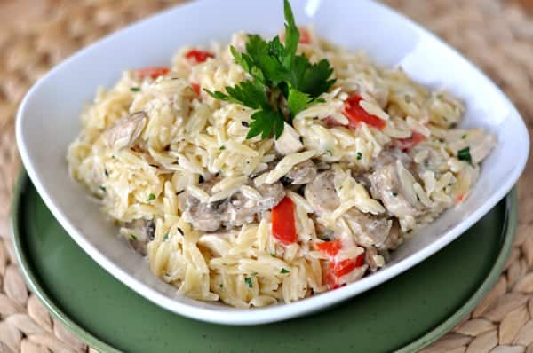 creamy orzo with mushrooms and peppers in a white bowl