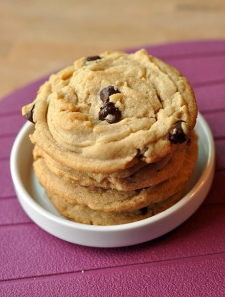 Peanut butter chocolate chip cookies stacked on top of each other in a white ramekin.