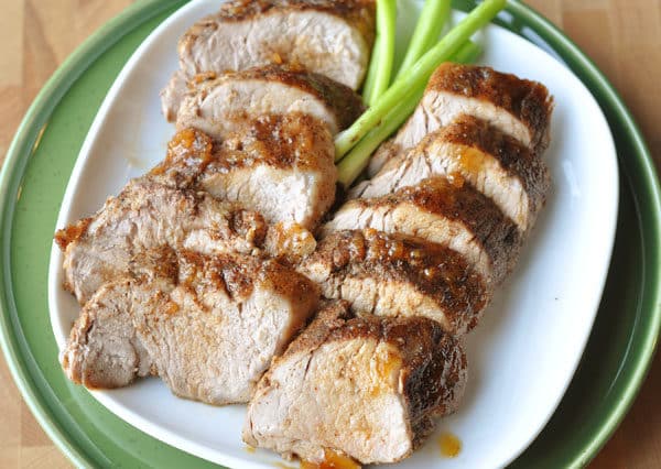 Top view of white plate with thick slices of pork loin.