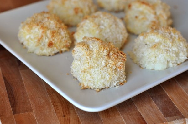 Small, golden potato puffs on a white rectangular platter.