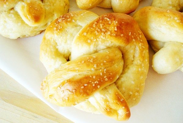 Salted chewy golden brown pretzels on a white plate.