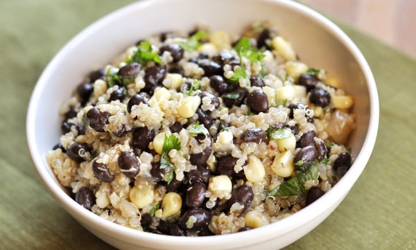 Looking down at a white bowl with quinoa, corn, and black beans.