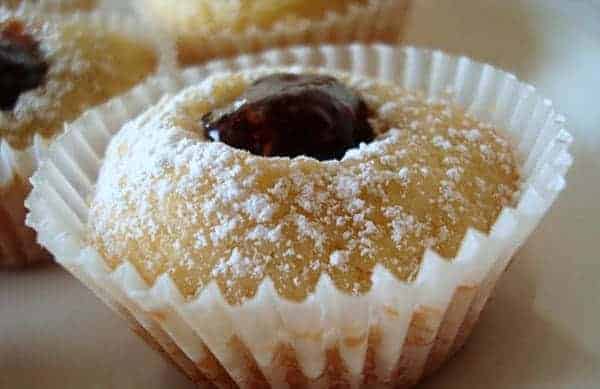 Shortbread cookie with a jam center in a white muffin liner.