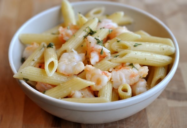white bowl full of cooked penne and shrimp