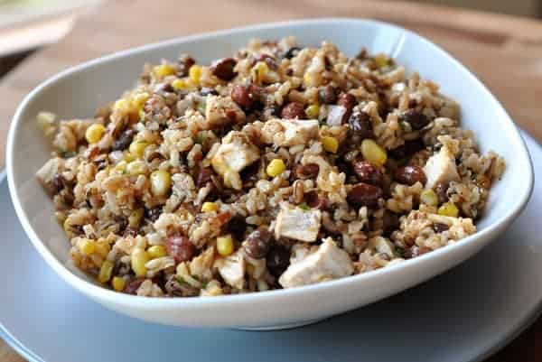 White bowl of rice, corn, chicken and beans.