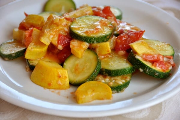 white plate tomatoes, and cooked zucchini and squash