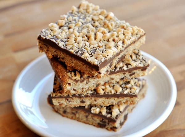 Chocolate toffee shortbread bars stacked on top of each other on a white plate.