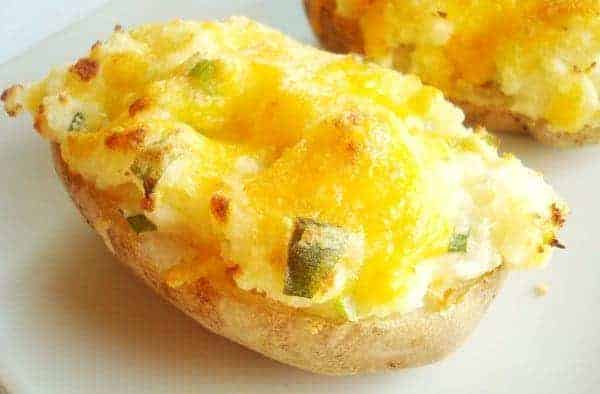 Baked potato with melted cheese and chopped chives.