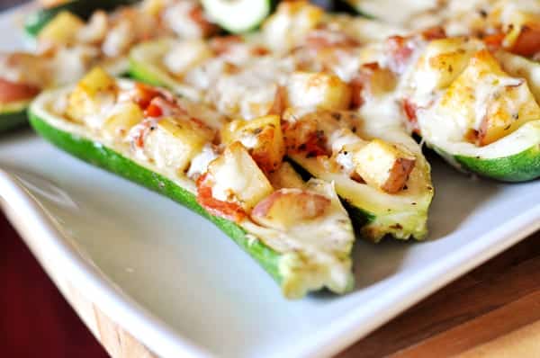 Stuffed zucchini on a white platter.