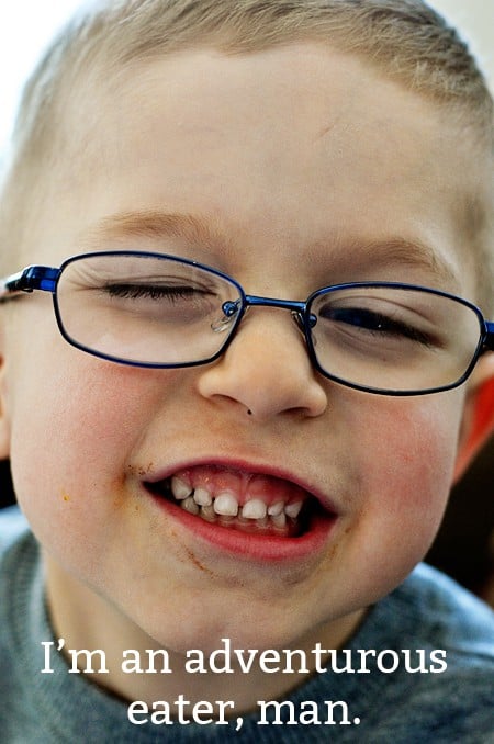 a little boy with glasses with a big smile on his face
