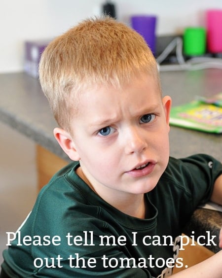 a little boy looking unhappy about eating his meal