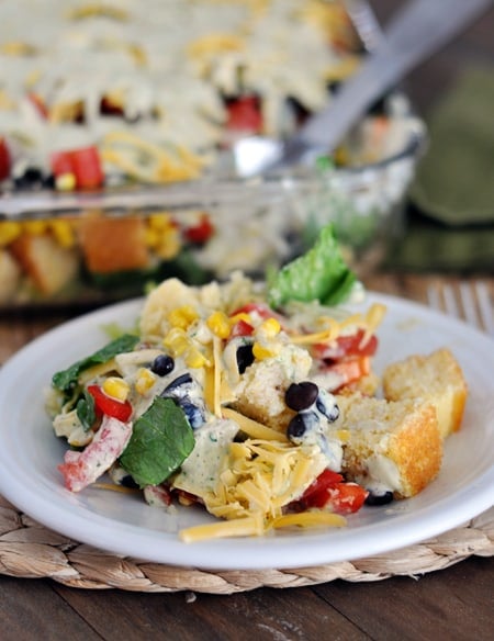 A white plate with a helping of Mexican cornbread salad.