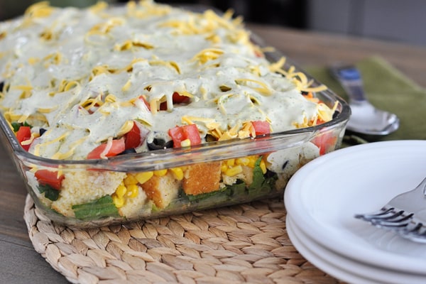 Glass 9x13 dish with a layered cornbread salad.
