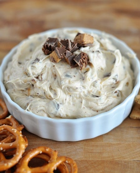 Top view of a white bowl full of peanut butter dip with chopped peanut butter cups on top.