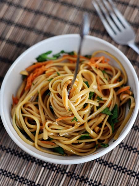 Top view of a white bowl of cooked thai linguine noodles.