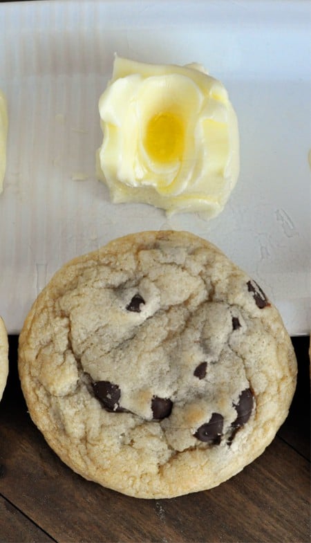 top view of a chocolate chip cookie and a slightly melted butter stick