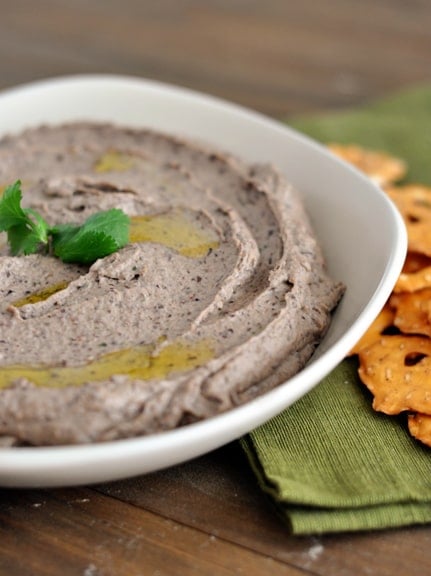 A white bowl full of black bean hummus.