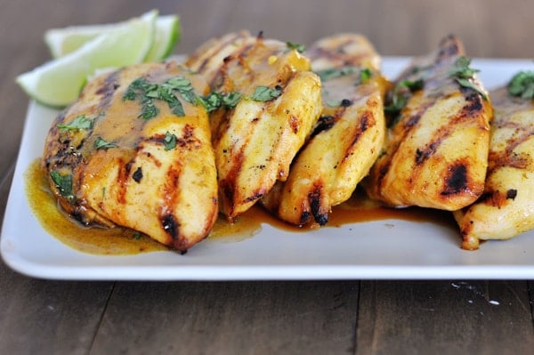 A white rectangular platter lined with grilled chicken.