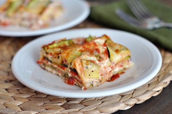 White plate with a piece of cheesy zucchini lasagna on it.