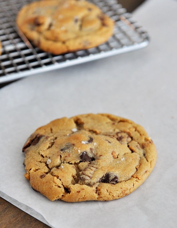 A salted chocolate chip peanut butter cup cookie on a piece of parchment.