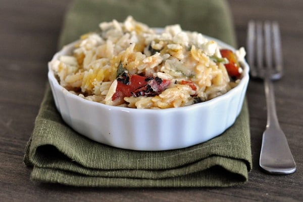 a small white ramekin filled with cooked cheesy orzo and tomatoes