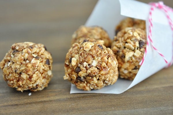 Chocolate chip granola bites spilling out of a white paper cone.