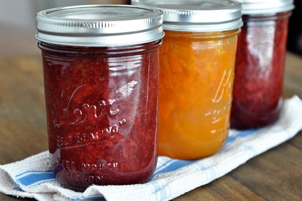 three mason jars full of jam lined up in a row
