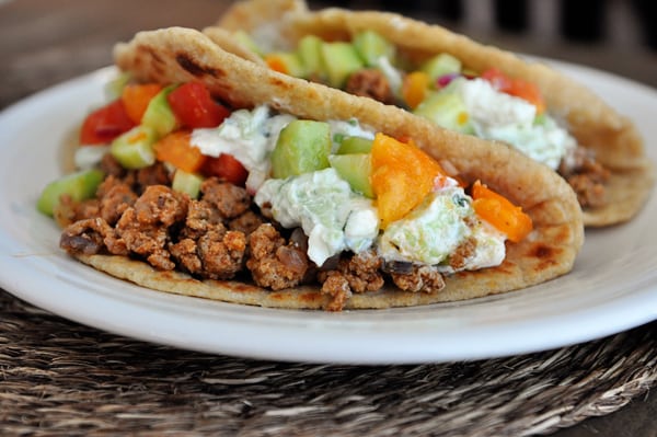 Two stuffed Greek tacos on a white plate.