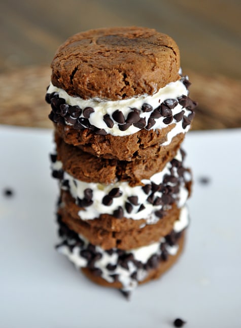 Three pumpkin chocolate chip ice cream sandwiches stacked on top of each other.