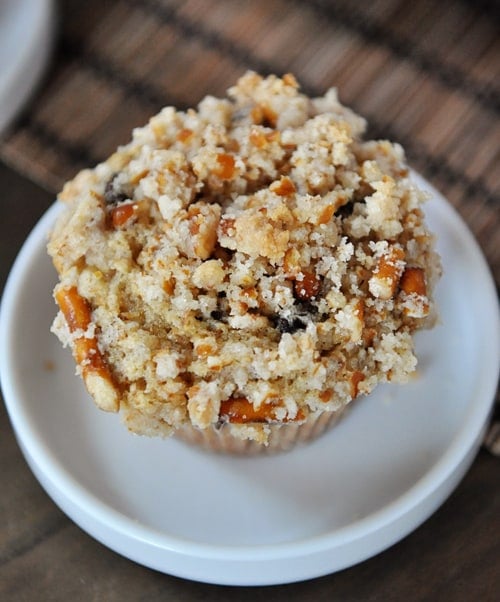 Top view of a pretzel-crusted chocolate chip muffin on a small white plate.