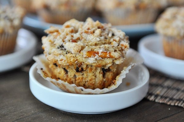 A pretzel-crusted chocolate chip muffin on a small white plate.