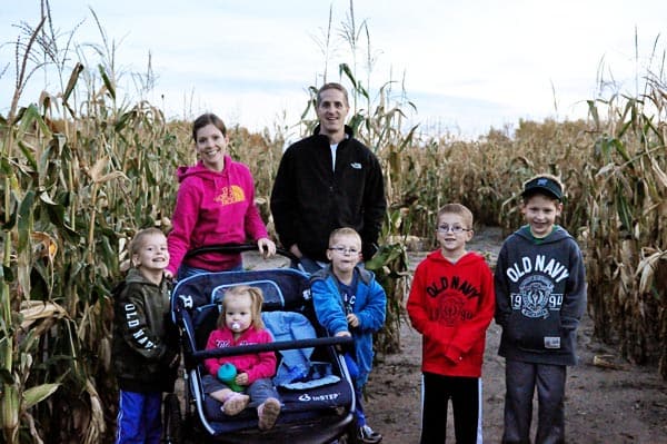 a mom, dad, and five kids in a corn maze