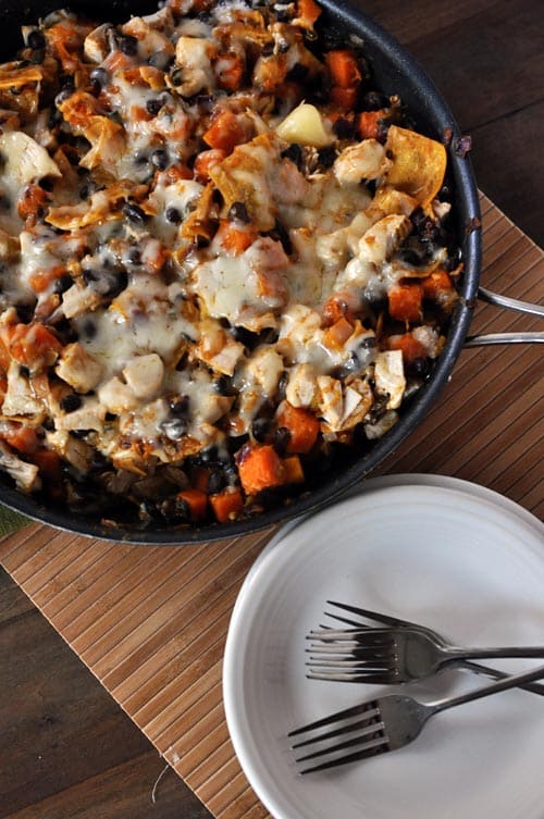 Top view of a cast iron skillet full of cheesy black bean enchilada casserole.