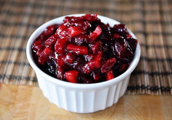 A white ramekin full of fresh cranberry chutney.