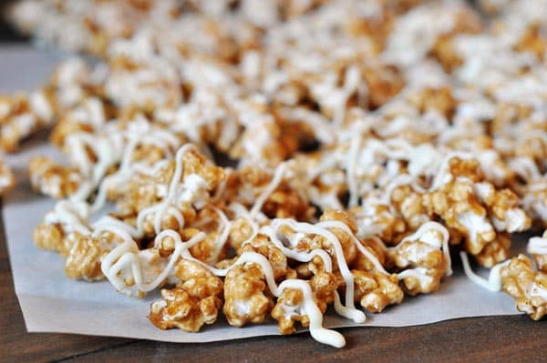 drizzled white chocolate cinnamon roll popcorn on a sheet of parchment