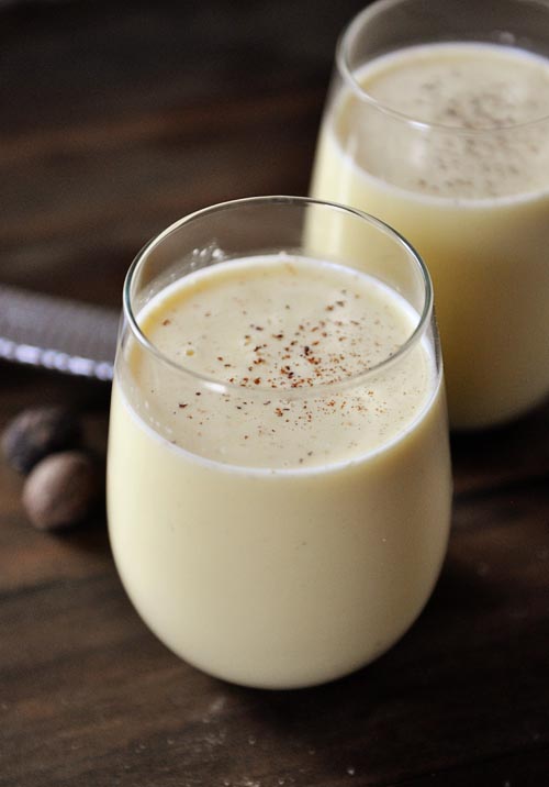 Glass full of homemade eggnog with sprinkled nutmeg on top.