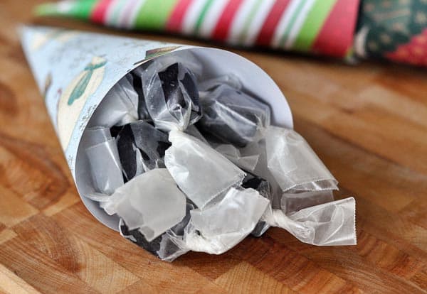 A paper cone filled with wrapped licorice caramels.