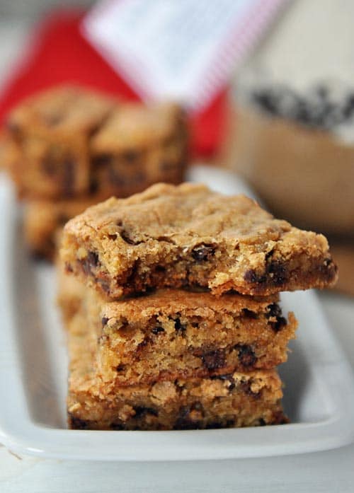 four chocolate chip toffee blondies stacked on top of each other