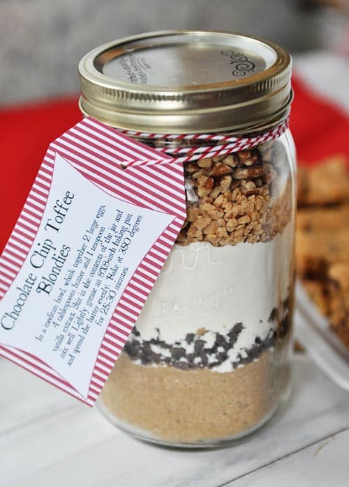 a glass mason jar with dry layered ingredients to make chocolate chip toffee blondies