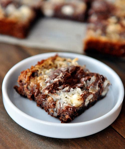 A square seven-layer chocolate bar in a small white ramekin.