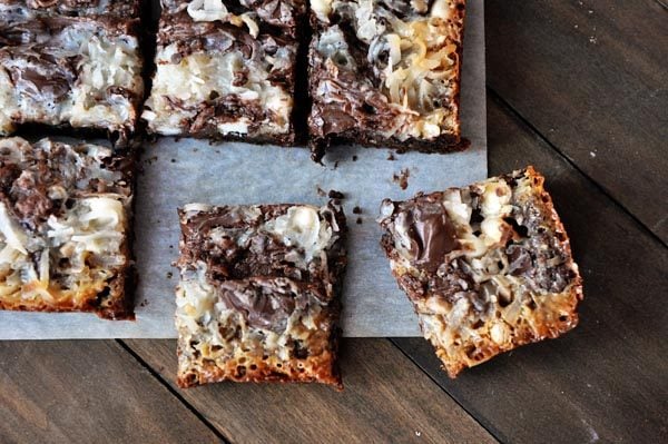 Top view of chocolate 7-layer bars cut into squares on a piece of parchment paper.