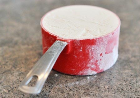 a red measuring cup full of flour
