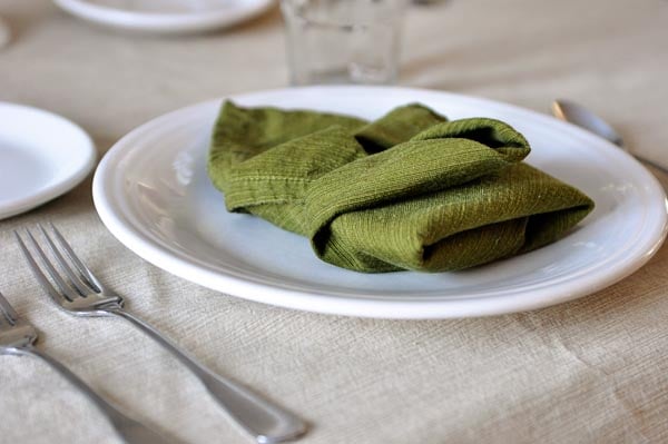 white plate with a green napkin folded on top