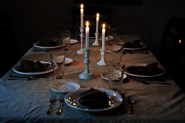 a dark room with a candelight dinner set up