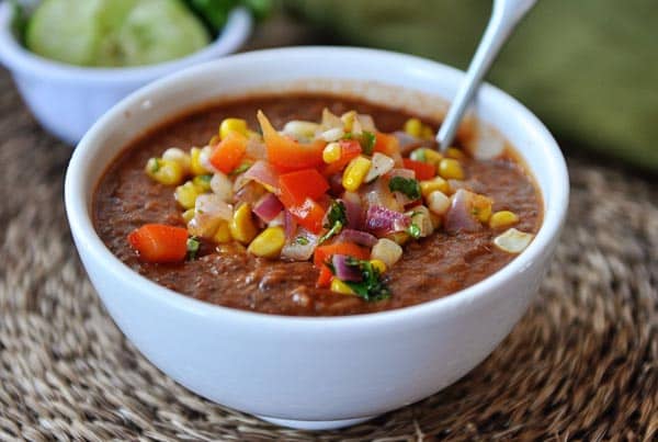 White bowl with a corn and tomato salsa-topped chili.
