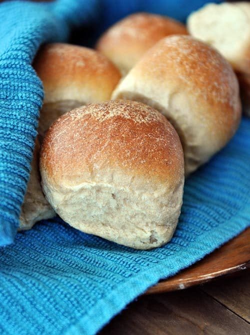 golden-brown cooked whole wheat rolls on a blue towel