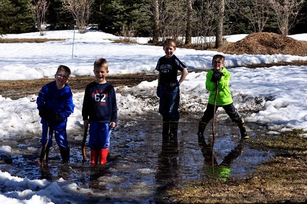 four little boys playing in icy water