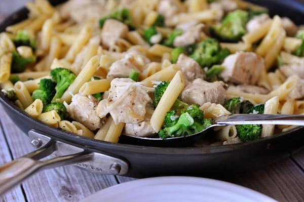 A skillet full of a chicken pasta and broccoli meal.