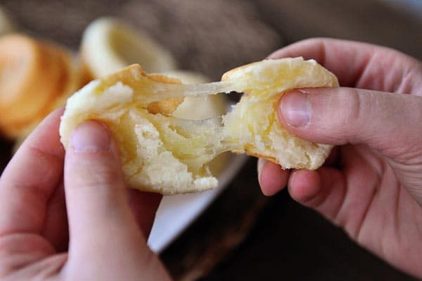 A Brazilian pao de queijo being split in half.